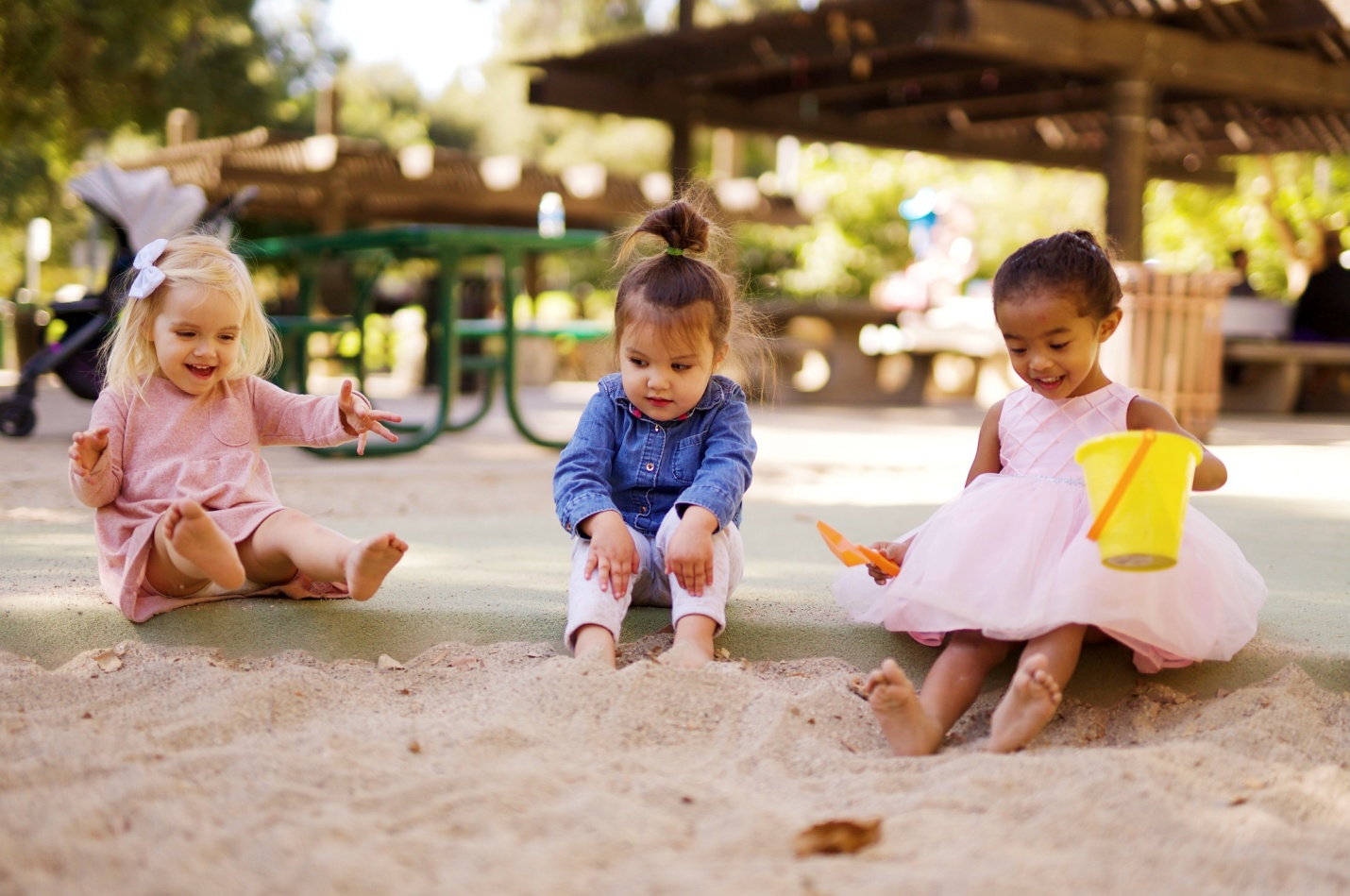 kids playing in a sand box at a playground